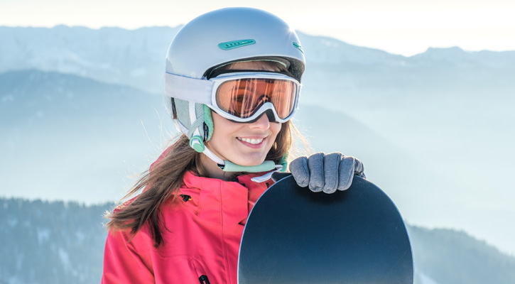 donna con occhiali e casco da sci in montagna