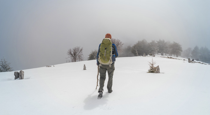 uomo con abbigliamento invernale su una montagna innevata